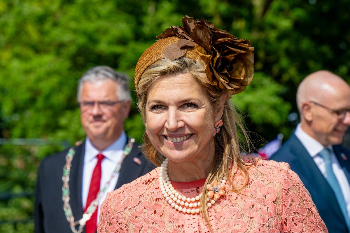 The Dutch queen elevated her ensemble with a dramatic floral fascinator and layered pearl necklace.