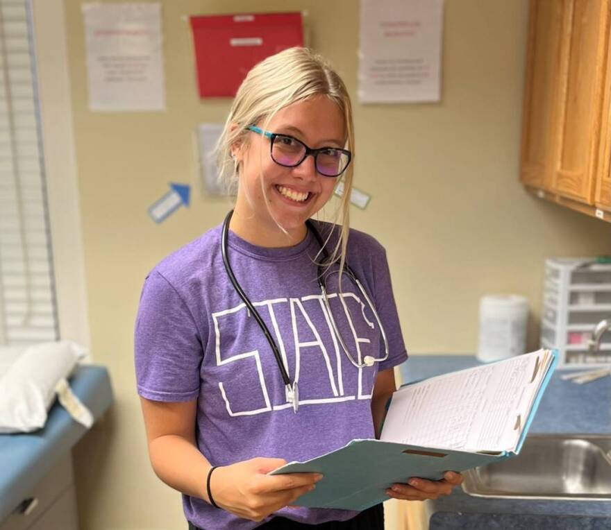 Employee of Manhattan Free Clinic in office studying charts.