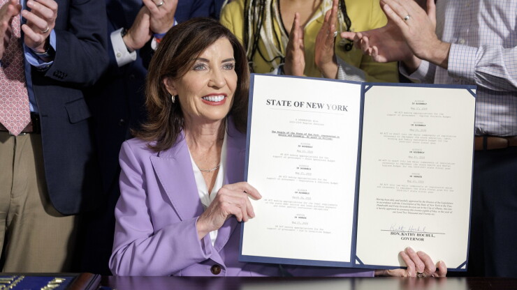 New York Gov. Kathy Hochul holds up signed state budget
