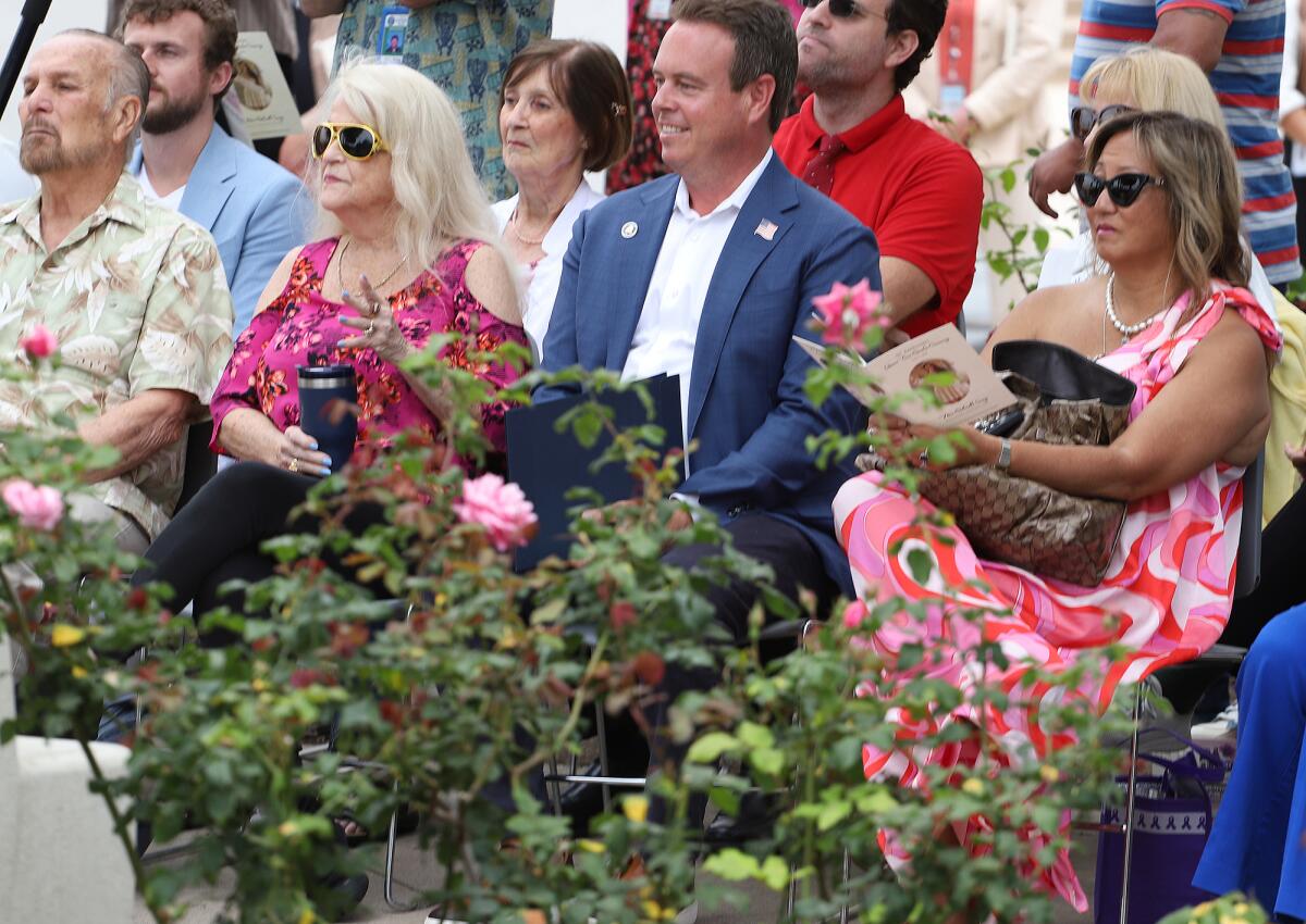 Huntington Beach Mayor Casey McKeon, center, sits with guests at the Queens' Rose Garden Ceremony on Friday.