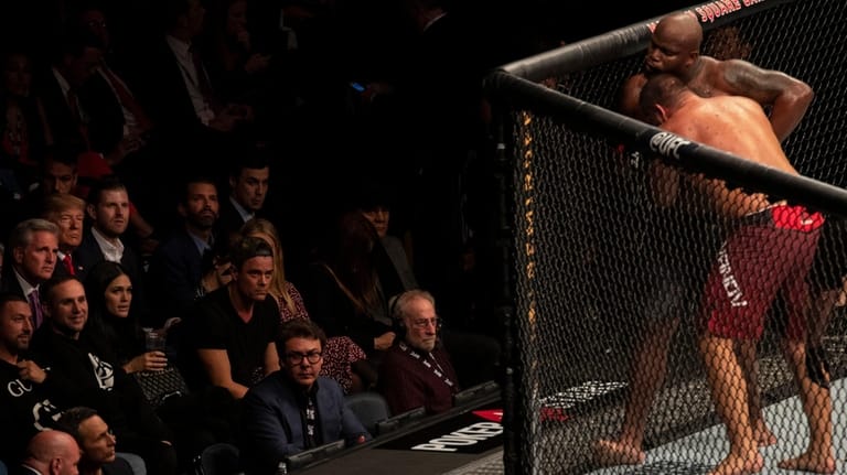 President Donald Trump watches Derrick Lewis fight Blagoy Ivanov, right,...
