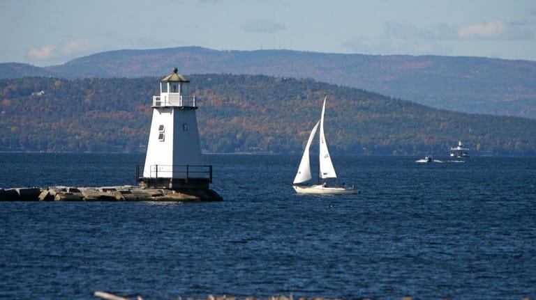 A sailboat travel across the water in Burlington, VT.