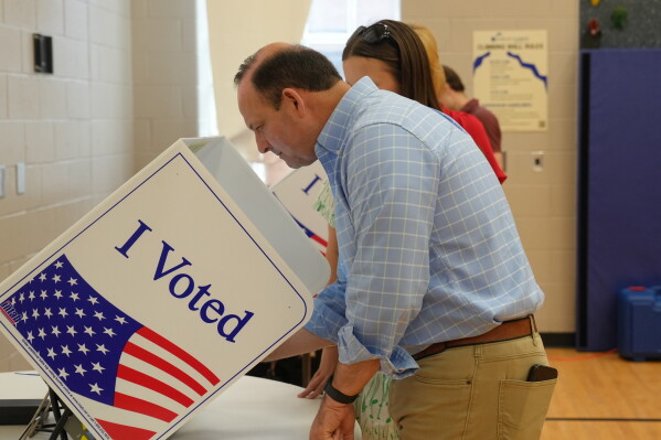 As his teenage daughter looks on, South Carolina Attorney General Alan Wilson, seeking to become the state's next governor, casts his ballot in the Republican primary runoff elections on Tuesday, June 23, 2026, in Lexington, S.C. (AP Photo/Meg Kinnard)