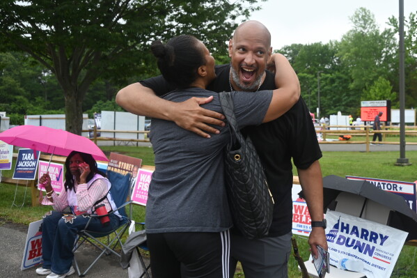 Harry Dunn, former U.S. Capitol police officer and candidate for U.S. Congress greets a voter Tuesday, June 23, 2026, in Upper Marlboro, Md. (AP Photo/Gail Burton)
