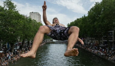 TOPSHOT - A swimmer dives into the Canal Saint-Martin, from an unapproved spot for swimming as France experiences a heatwave in Paris on June 20, 2026. Due to the ongoing heatwave sweeping across France - the Bassin des Recollets - a portion of the Canal Saint-Martin in the French capital has been opened for swimming from June 17. France issued a red heatwave alert across more than a third of the country for June 21, as a ferocious heatwave dug in and the government banned the consumption of alcohol in certain areas during the annual Fete de la Musique festivities. (Photo by ARNAUD FINISTRE / AFP via Getty Images)