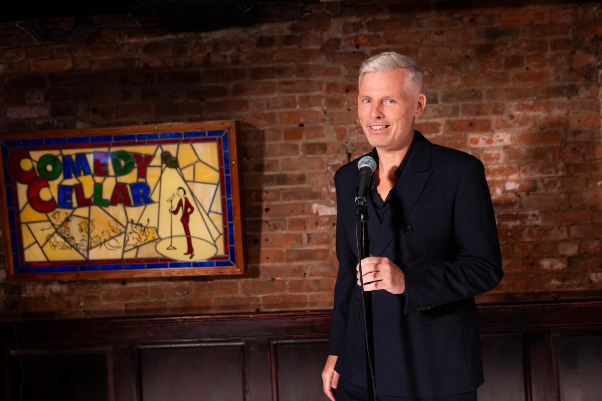 Man standing on stage at the Comedy Cellar