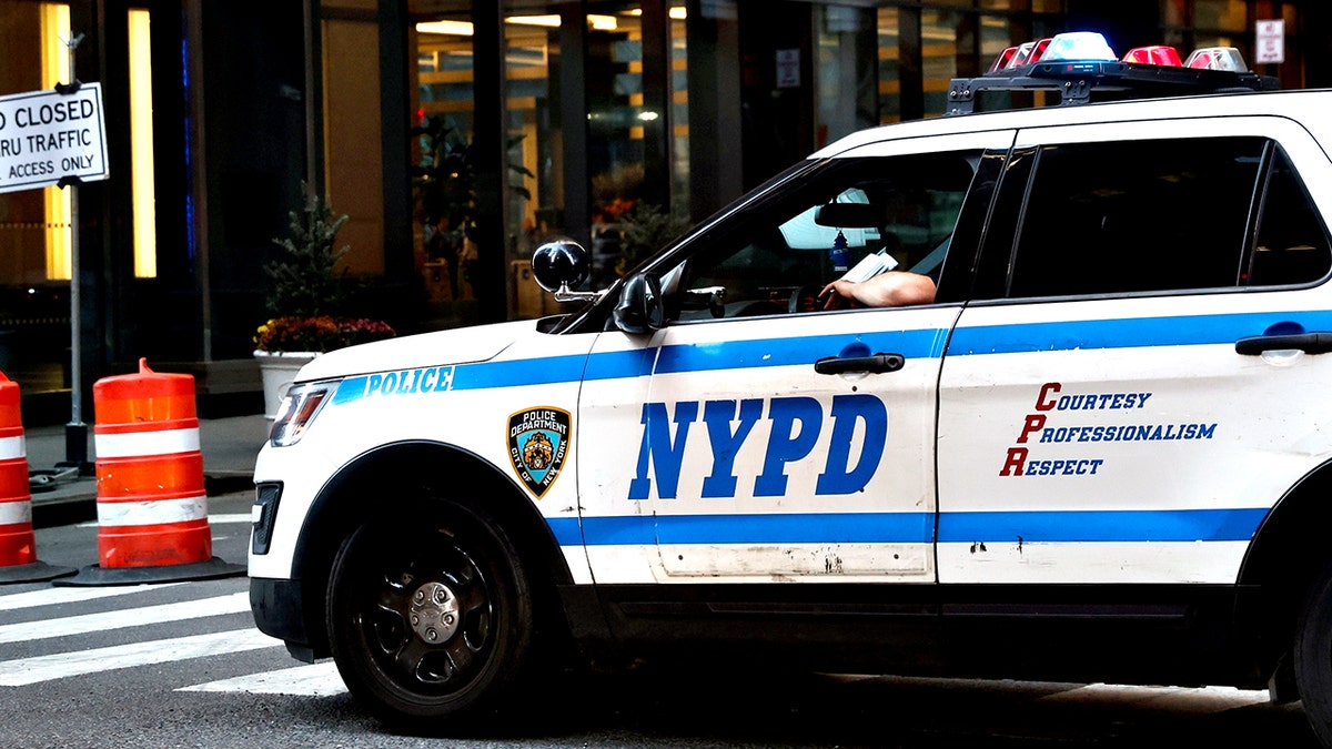 An NYPD cruiser parked at an intersection on a Midtown street in New York