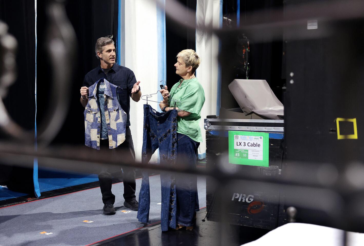 Ryan Sander, assistant choreographer, left, and Eva Maciek, travel costume supervisor of the show, show off Sander's "Voulez-Vous" costume.