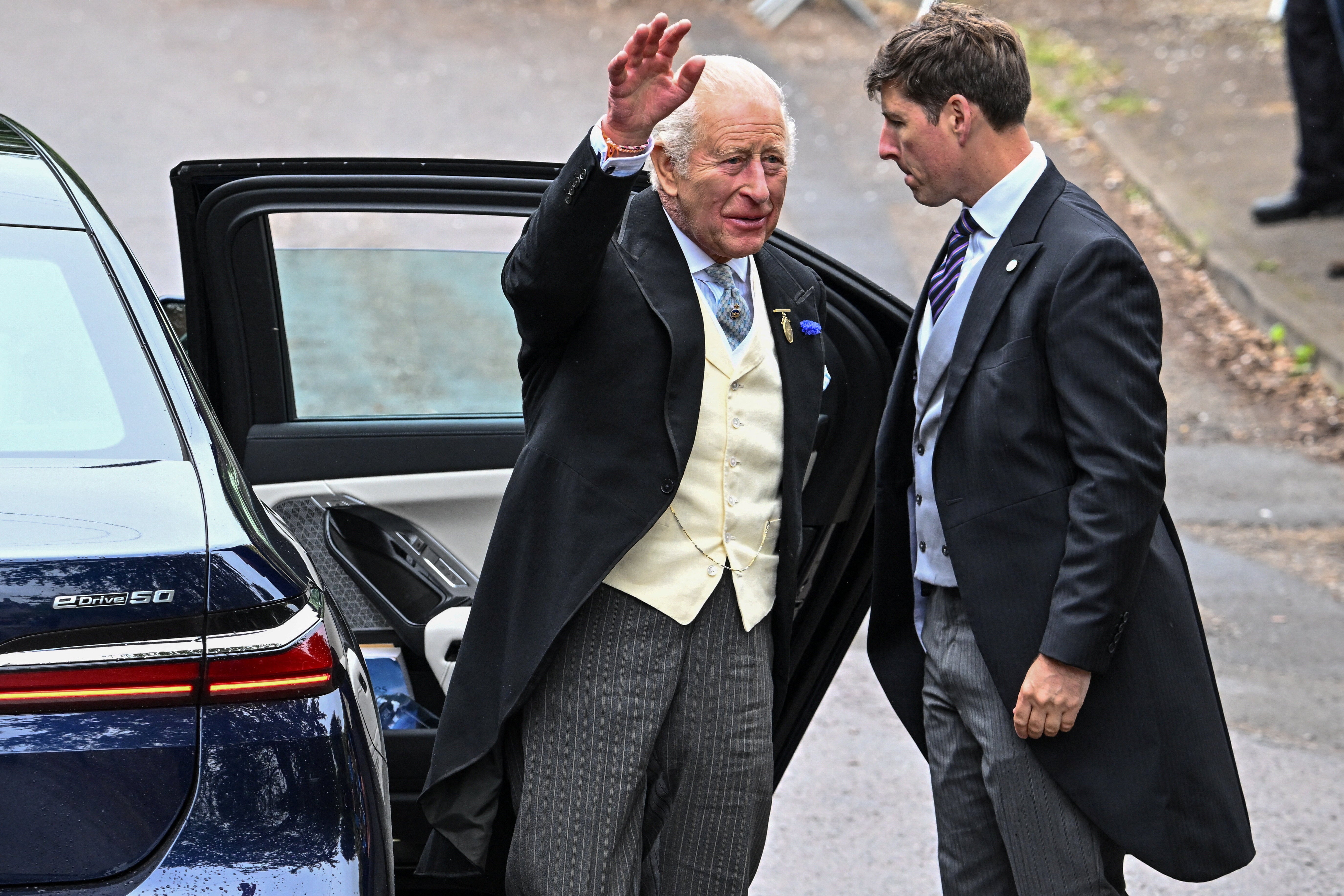 King Charles waves as he arrives to attend the wedding of Princess Anne's son, Peter Phillips and Harriet Sperling at All Saints' Church