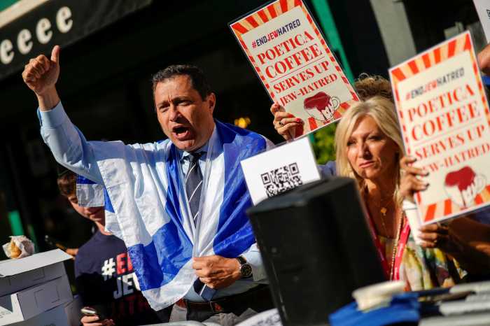demonstrators ouside of a Brooklyn coffee shop holding signs