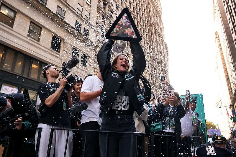 FILE - New York Liberty guard Sabrina Ionescu holds up the WNBA basketball championship trophy while riding down Broadway during a parade celebrating the team's season championship, Oct. 24, 2024, in New York. (AP Photo/Yuki Iwamura, File)