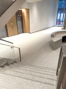 lobby floor in terrazzo with monochrome handcrafted desk and base of stairs
