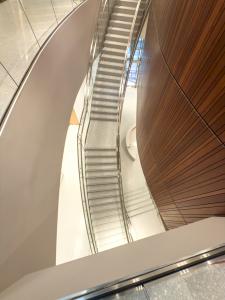 view of the stair case in terrazzo, with first floor desk in terrazzo and wood wall