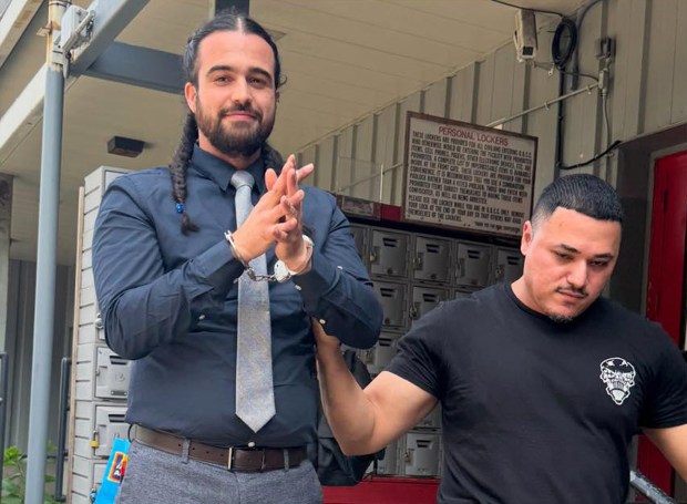 A Department of Correction Intelligence Bureau officer escorts attorney Bernardo Caceres out of the Otis Bantum Correctional Center on Rikers Island.