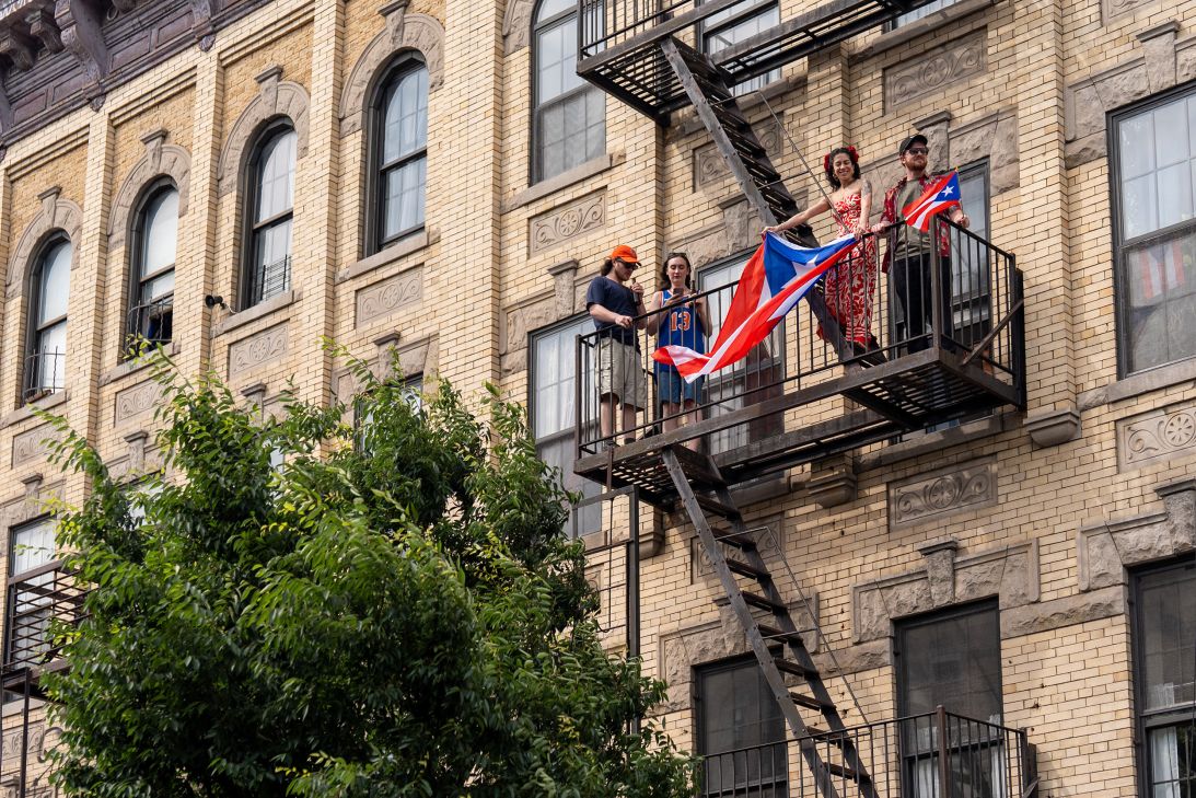 People watch the Puerto Rican Day celebration from a fire escape in Bushwick.