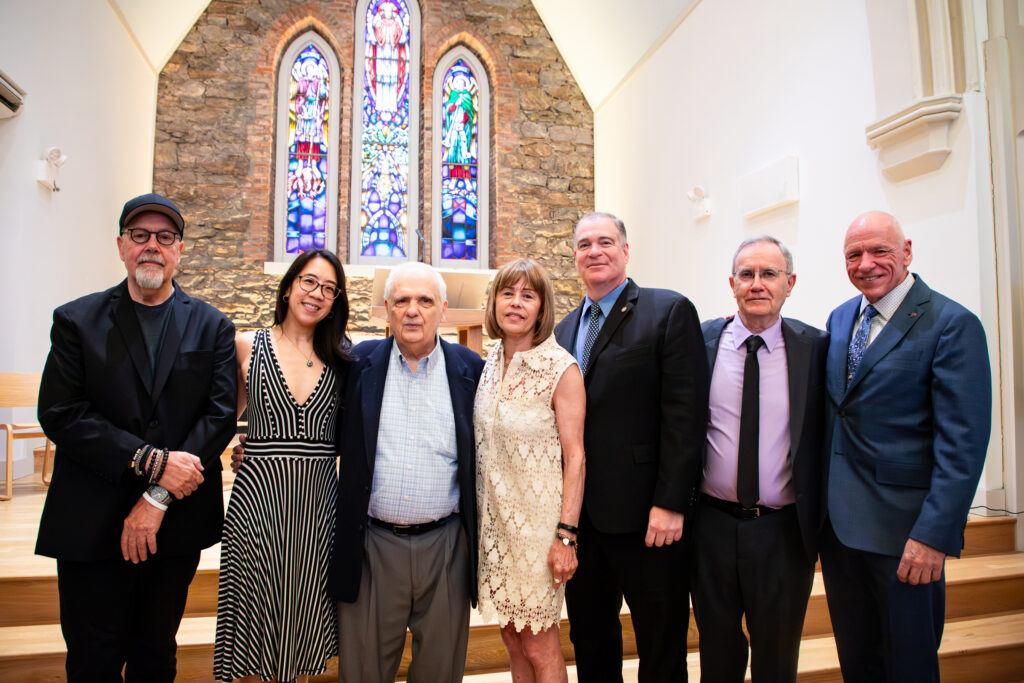 Speakers and honorees in Ascension Hall at the North Brooklyn Angels 6th annual luncheon; from left to right: Paul Samulski, Kendra Chiu, Joseph Lentol, Elaine Brodsky, William Lynn, Neil Sheehan and Eddie Christian. Photo: Julie Thompson/Brooklyn Eagle