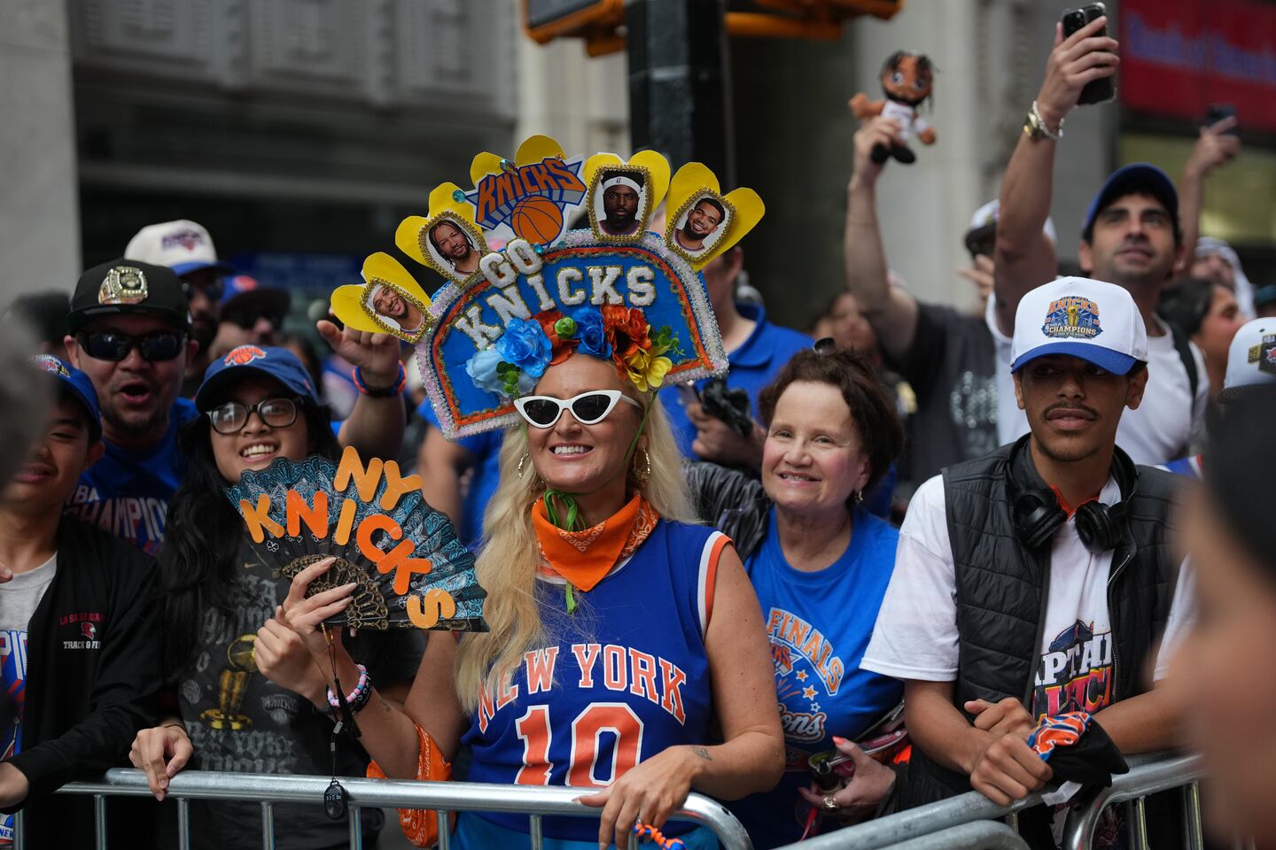 People wait for the start of the New York Knicks ticker-tape parade to celebrate their first NBA championship win in two generations in New York on Thursday.