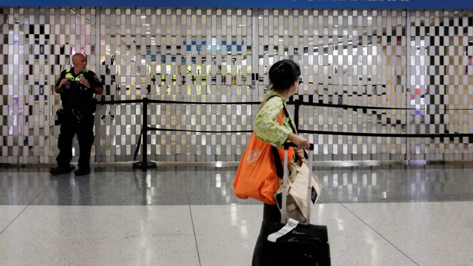 A woman walks by a closed entrance to the station after the stabbing incident Sunday. - Jeenah Moon/Reuters