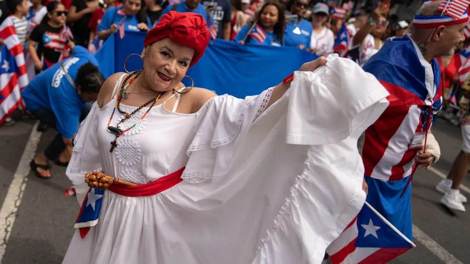 A dancer poses in the street during the annual Knickerbocker Avenue Puerto Rican Day Parade. - David Dee Delgado for CNN