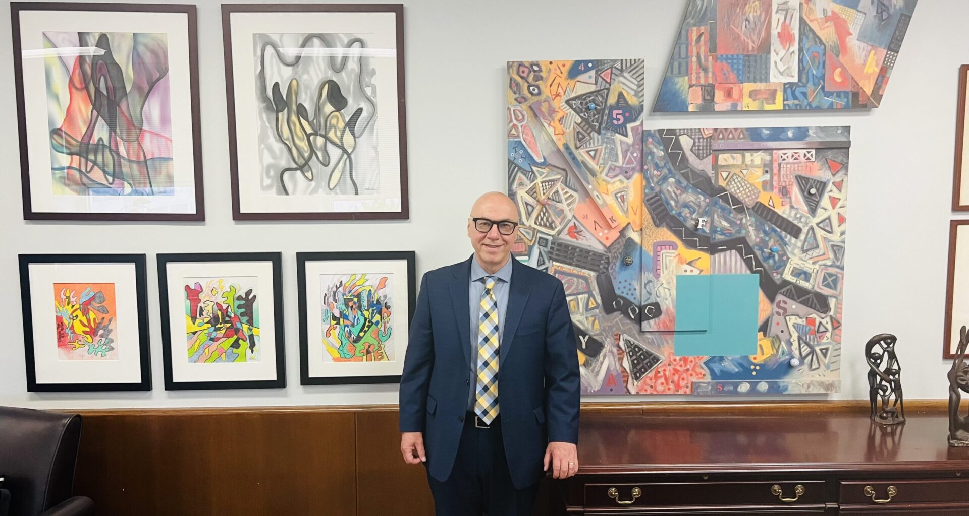Judge Montelione alongside some of the many pieces of artwork in his office. Photo: Wayne Daren Schneiderman/Brooklyn Eagle