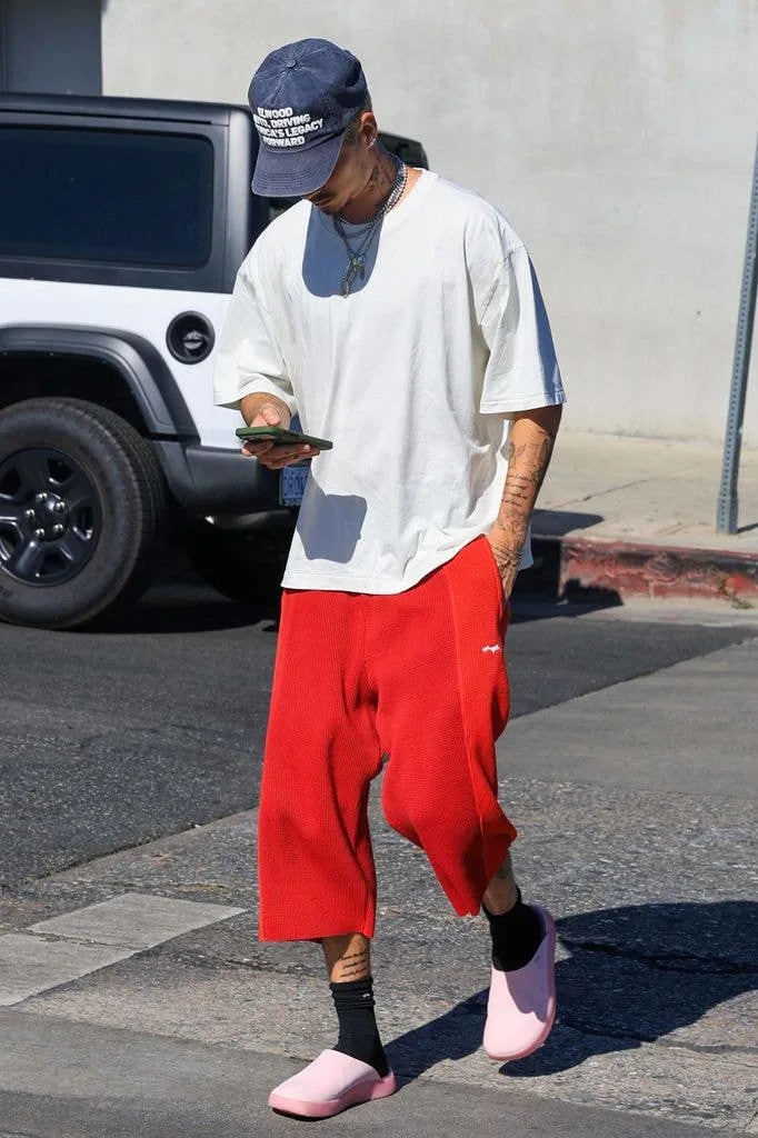 Romeo Beckham in a white top and hat