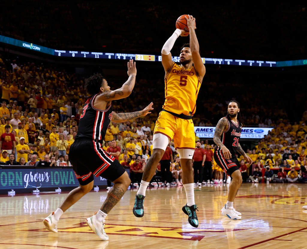 Joshua Jefferson of the Iowa State Cyclones takes a shot as Ramon Walker Jr. and Emanuel Sharp of the Houston Cougars defend.