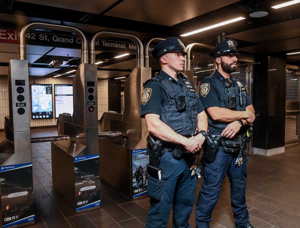 FILE - Police officers stationed at a subway turnstile to combat fare evasion.