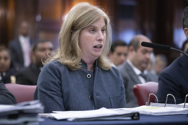 NYPD Commissioner Jessica Tisch speaking at microphone while seated at table