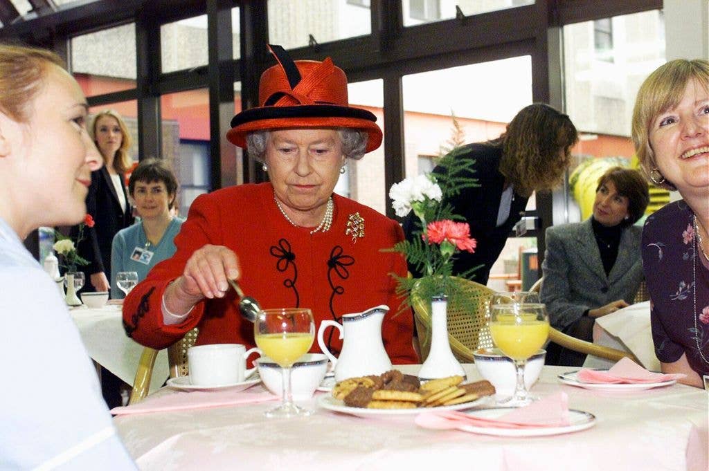 MANCHESTER - OCTOBER 15:  Queen Elizabeth II takes a tea break with hospital staff during her visit to Manchester Royal Infirmary on October 15, 1999. (Photo by Anwar Hussein/Getty Images)