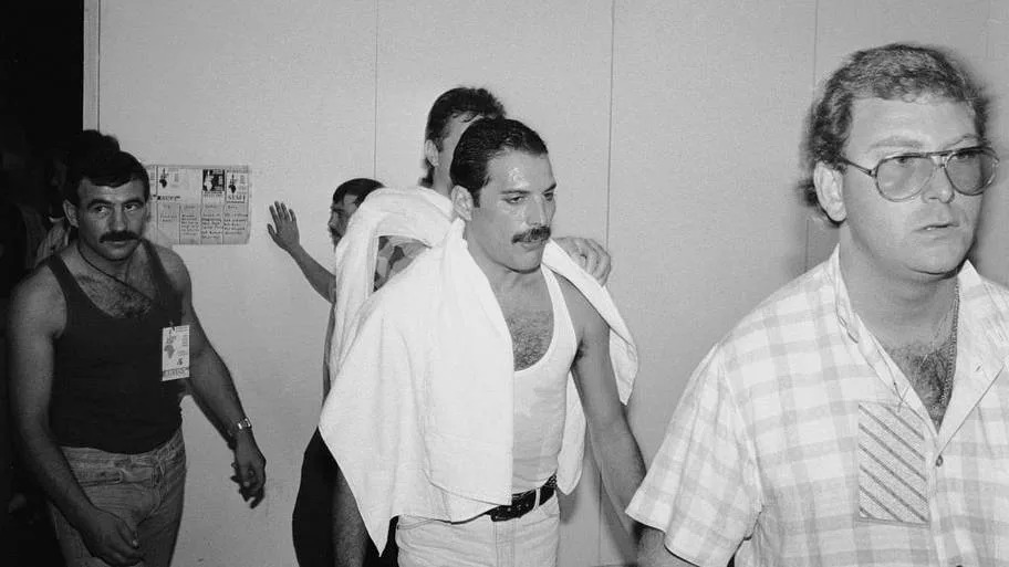 Freddie Mercury backstage at Live Aid followed by boyfriend Jim Hutton