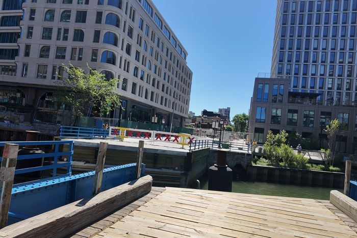 The bridge slides across the canal diagonally, carried on railcar-style wheels and tracks.