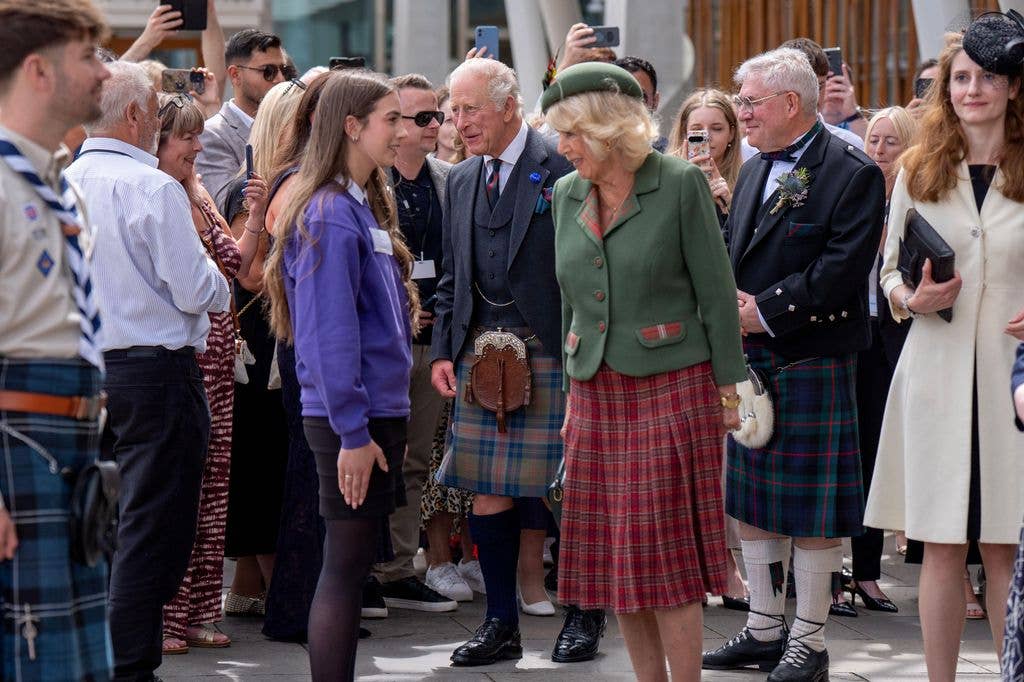A photo of Queen Camilla talking to a young girl