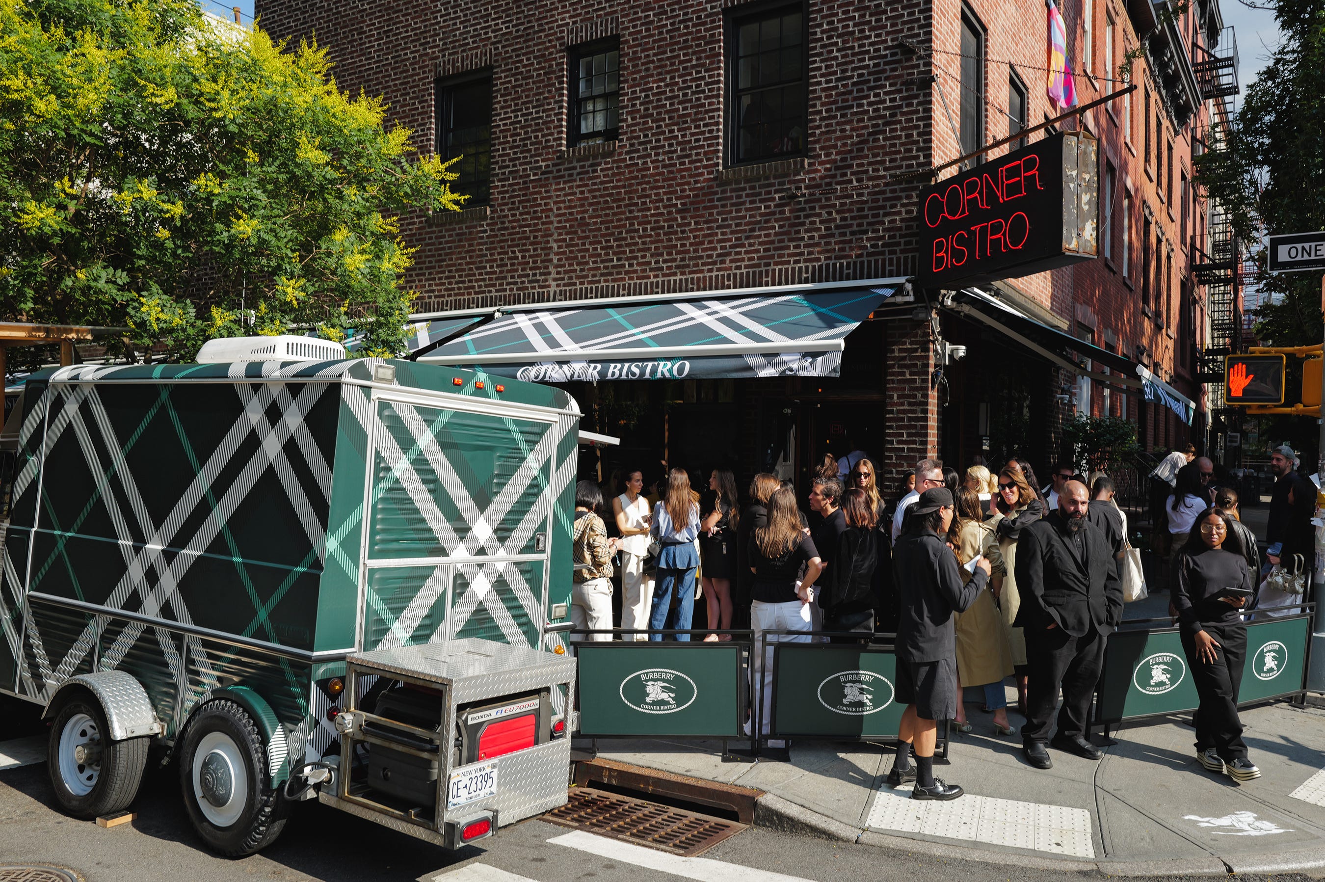 People gathered outside Corner Bistro on a sunny day.