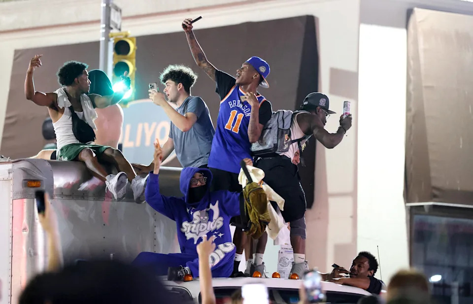 New York Knicks fans climb on a truck as they celebrate outside Madison Square Garden after their team's Game 4 victory over the San Antonio Spurs in the NBA Finals in New York on June 10, 2026.