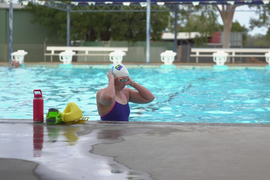 Woman in pool preparing to swim.