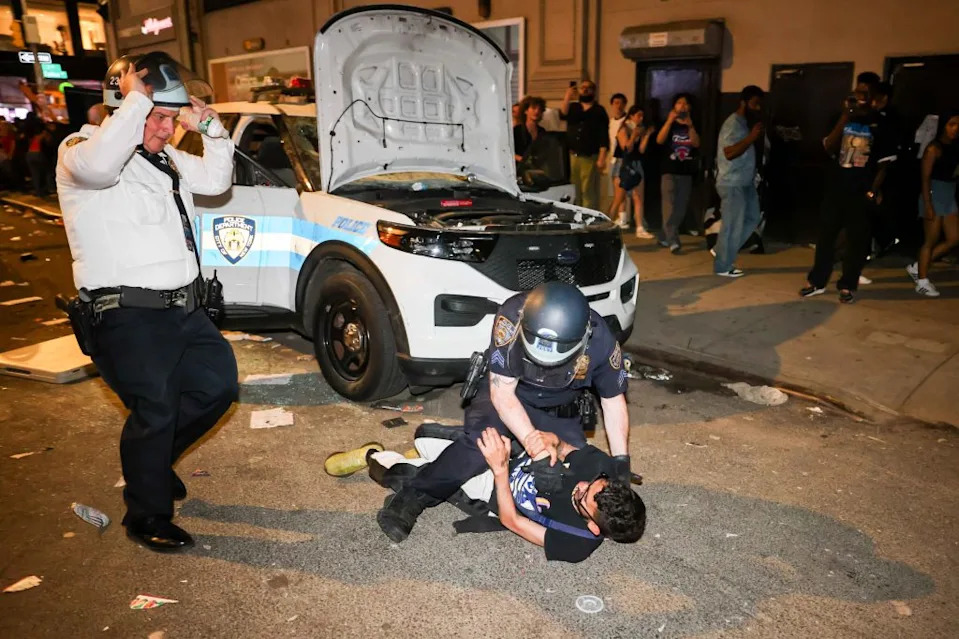 A person is detained in front of a destroyed NYPD vehicle during a chaotic scene in New York on June 14, 2026. Michael Nagle for NY Post