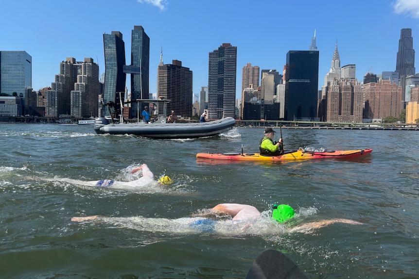 Swimmers with New York City in the backdrop.