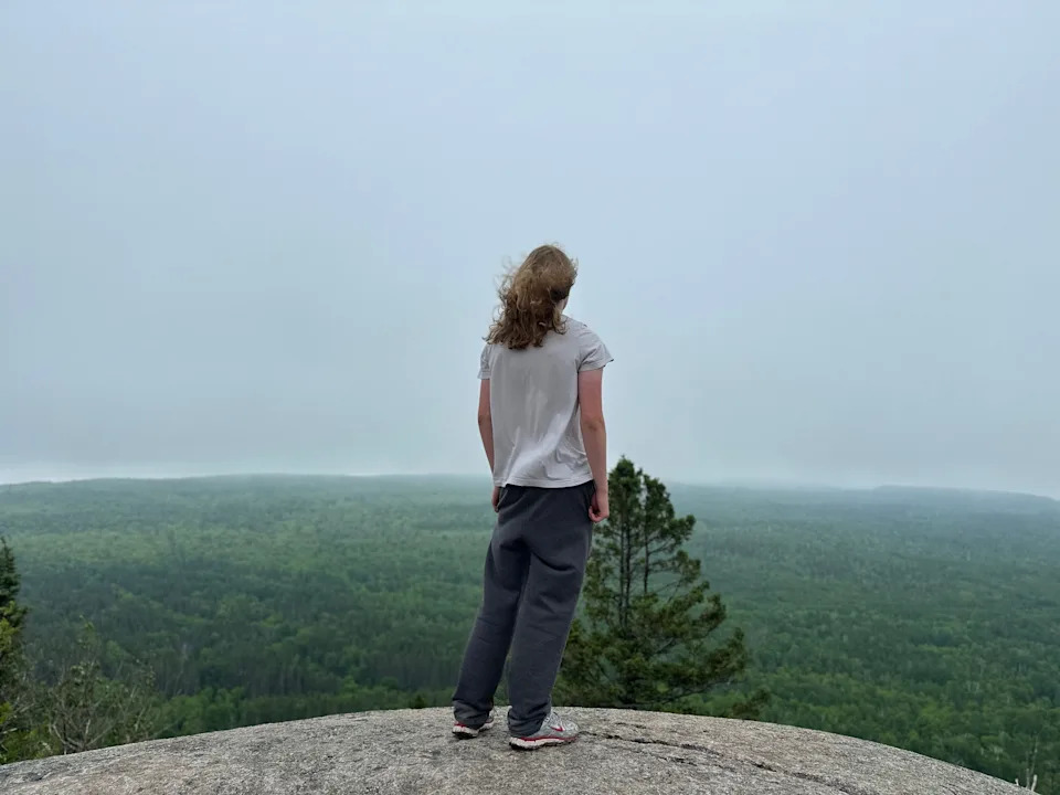 The author's teen son stands on a rock overlooking a vista.