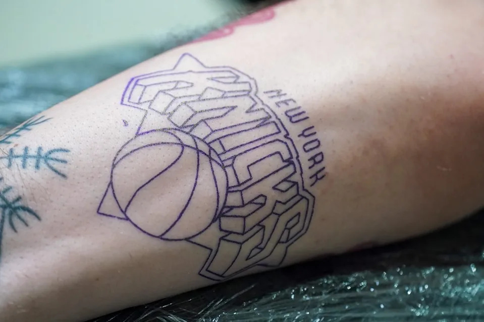 Tattoo artist Val inks a Knicks logo on fan Craig Stevens. Robert Miller for NY Post