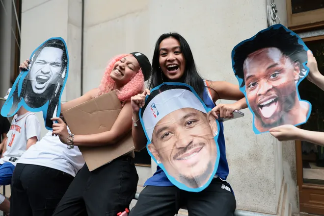 NEW YORK, NEW YORK - JUNE 18: Fans poses with posters of Jose Alvarado #5, Josh Hart #3 and Og Anunoby #8 of the New York Knicks ahead of the New York Knicks Championship ticker tape parade and victory rally celebrating winning the 2026 NBA Finals on June 18, 2026 in New York City. The New York Knicks defeated the San Antonio Spurs in five games to win their first NBA Championship in 53 years.