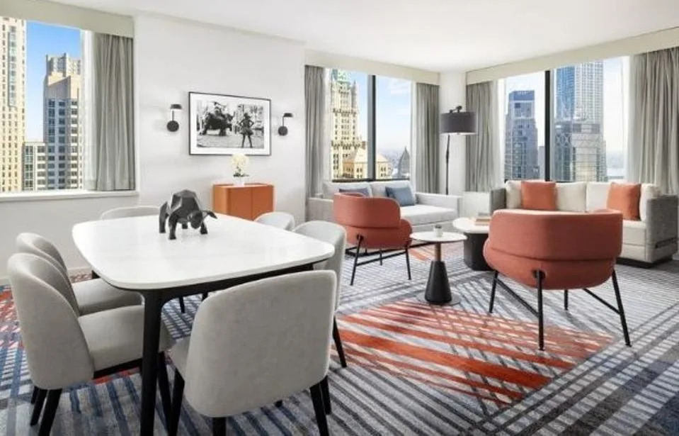 Several tables and chairs in a hotel suite in New York.