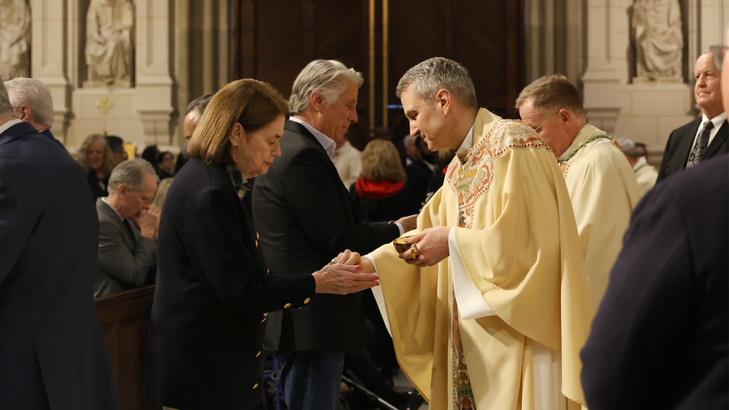 Archbishop Ronald Hicks (center) distributes communion during a May 14, 2026 Mass at St. Patrick’s Cathedral.