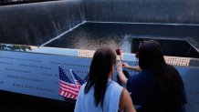 FILE - Ainsley, right, and Sarah Jurccak place a flower in the name of a relative during a ceremony to mark the 24th anniversary of the 9/11 attacks, Sept. 11, 2025, in New York. (AP Photo/Seth Wenig, File)
