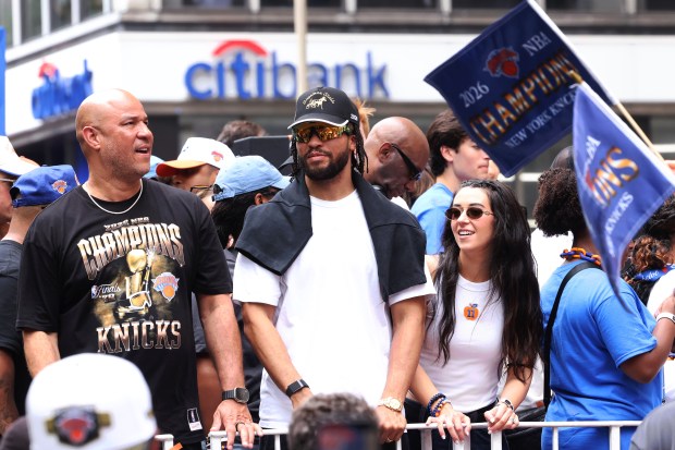 New York Knicks player Jalen Brunson, center, celebrates the team's NBA championship with his father Rick Brunson, left, and wife Ali Brunson during a ticker-tape parade down Lower Manhattan's "Canyon of Heroes" on Broadway, Thursday, June 18, 2026 in New York. This was the Knicks' first NBA championship in 53 years. (Jason DeCrow/Alliance for Downtown New York via AP Content Services)