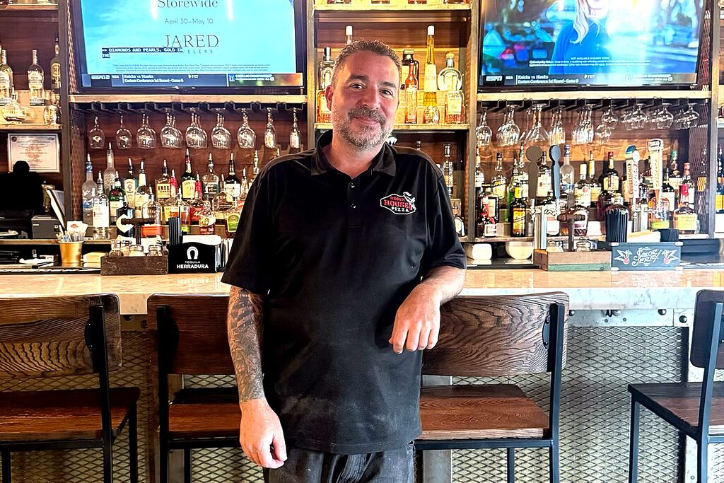 Adam Calandra is standing in front of Bronx House Pizza's St. Augustine bar.