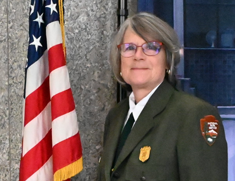 A woman wearing a National Park Service uniform and glasses.