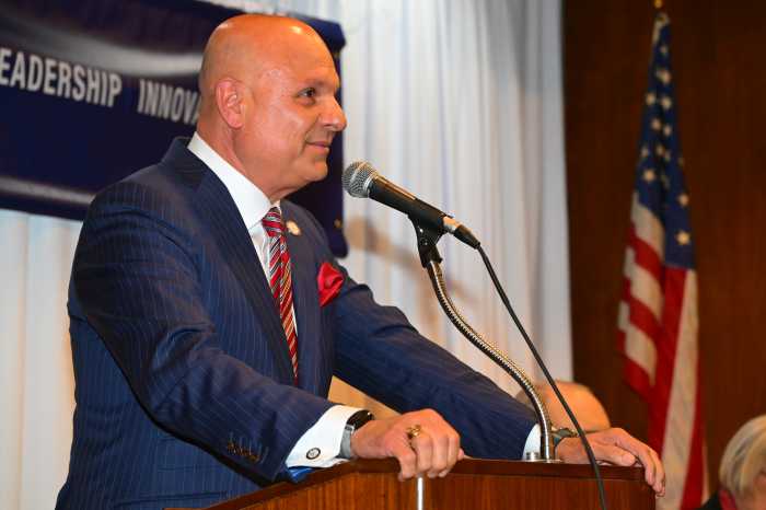man in a suit speaking into a podium