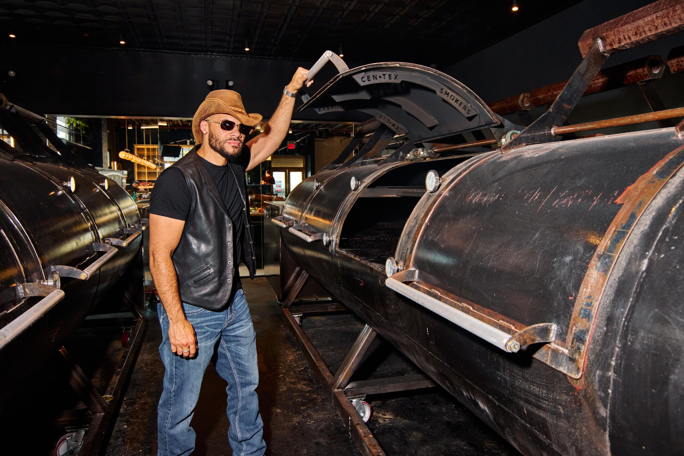A man opening a smoker in a big room.