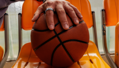 Man's hand holding basketball and wearing Oura Ring