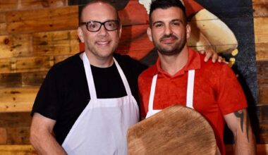 Bruno DiFabio and Mike Bennici, wearing aprons and holding a pizza pallet.